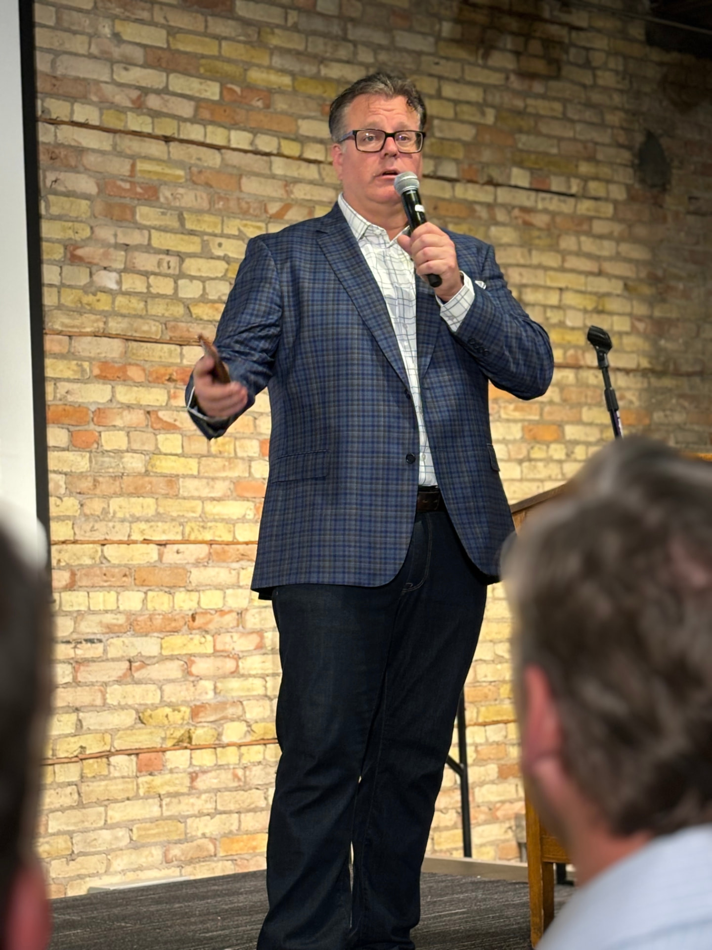 Reid Holmes speaking on stage with a microphone